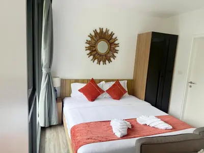 a bedroom with a bed with red pillows and a mirror at \u8d85\u4fbf\u5229 199\u53f7\u82ad\u4e1c\u6d77\u6ee9\u7cbe\u88c5\u516c\u5bd3 5\u5206\u949f\u5230\u6d77\u6ee910\u5206\u949f\u5230\u9152\u5427\u8857 in Patong Beach