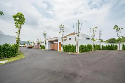 a street with a house and trees on the side at Mouana Residence Song Khun Chalong VIP4-bedroom Pool Villa 89-14 in Chalong