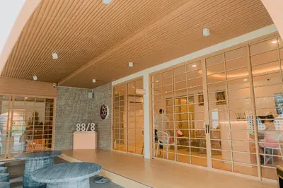 a room with glass walls and tables in a building at Baan Cocoa Boutique Hotel in Natai Beach