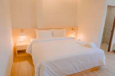 a bedroom with a large white bed with white sheets at Baan Cocoa Boutique Hotel in Natai Beach