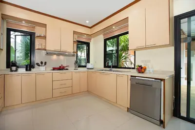 a large kitchen with tan cabinets and appliances at Balinese-Style 3Bedrooms Villa Tina in Kata Beach