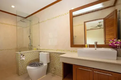 a bathroom with a sink and a toilet and a mirror at Balinese-Style 3Bedrooms Villa Tina in Kata Beach