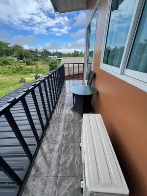 a porch with a bench and a table on a balcony at Anda Mantham Hill in Ban Bang Rong
