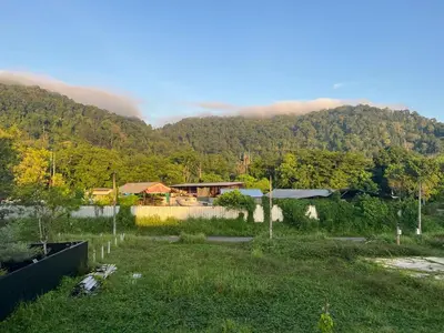 a house in a field with a mountain in the background at Anda Mantham Hill in Ban Bang Rong