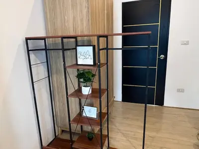 a book shelf with two pictures and a plant on it at Anda Mantham Hill in Ban Bang Rong