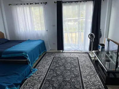 a bedroom with a bed and a window and a rug at Anda Mantham Hill in Ban Bang Rong
