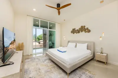 a bedroom with a bed and a flat screen tv at Oxygen Villas with Private Pool Near Naiharn by TropicLook in Rawai Beach