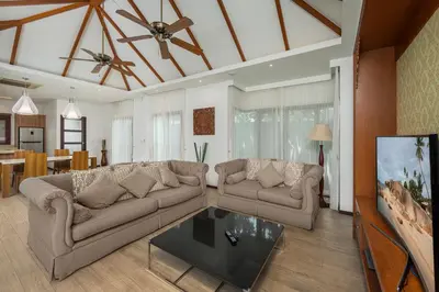 a living room with two couches and a tv at Oxygen Villas with Private Pool Near Naiharn by TropicLook in Rawai Beach