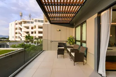 a balcony with chairs and tables on a building at Mida Grande Resort 1106 by Phuket Sabay Rent in Surin Beach