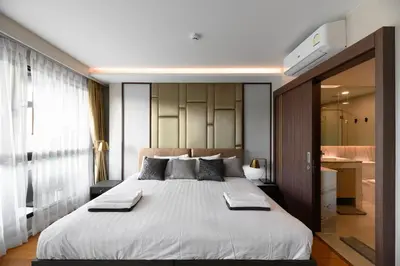 a bedroom with a large bed with towels on it at Mida Grande Resort 1106 by Phuket Sabay Rent in Surin Beach