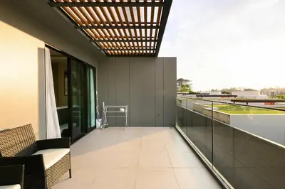 a balcony with a couch and chairs on a building at Mida Grande Resort 1106 by Phuket Sabay Rent in Surin Beach