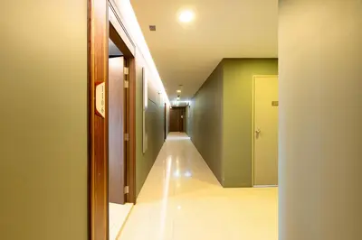 a hallway with green walls and a white tile floor at Mida Grande Resort 1106 by Phuket Sabay Rent in Surin Beach