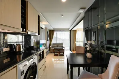 a kitchen and living room with a washer and dryer at Mida Grande Resort 1106 by Phuket Sabay Rent in Surin Beach