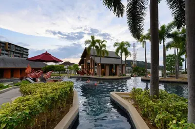 a pool at a resort with palm trees at Mida Grande Resort 1106 by Phuket Sabay Rent in Surin Beach