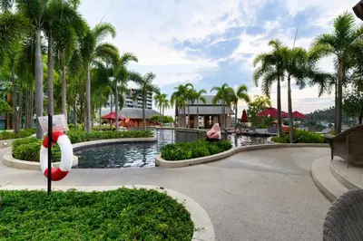 a pool at a resort with palm trees at Mida Grande Resort 1106 by Phuket Sabay Rent in Surin Beach