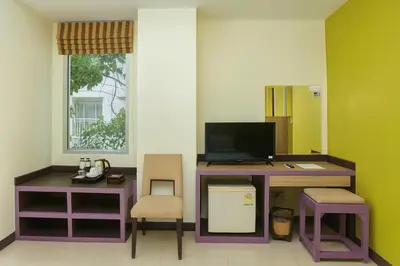 a room with a desk with a computer and chairs at Bellevue Ocean Patong in Patong Beach