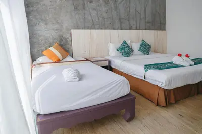 a room with two beds with towels on them at Bellevue Ocean Patong in Patong Beach
