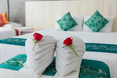 two roses on a bed in a hotel room at Bellevue Ocean Patong in Patong Beach