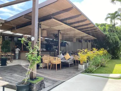a patio with tables and chairs under a pergola at Lokal Phuket 