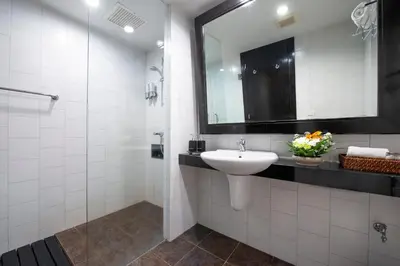 a white bathroom with a sink and a mirror at Lokal Phuket 