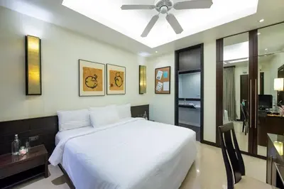 a bedroom with a white bed and a ceiling fan at Lokal Phuket 