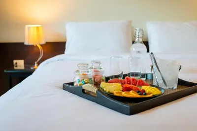 a tray of fruit and drinks on a bed at Lokal Phuket 