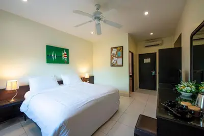 a bedroom with a white bed and a ceiling fan at Lokal Phuket 