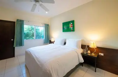 a bedroom with a white bed and a window at Lokal Phuket 