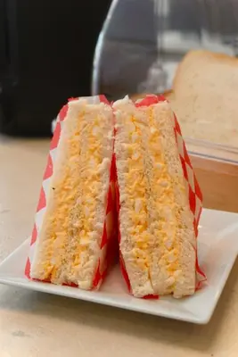 a sandwich cut in half on a white plate at Kuha Phuket Old Town in Phuket Town