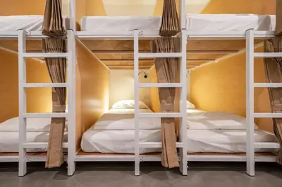 a room with three bunk beds in a hostel at Kuha Phuket Old Town in Phuket Town