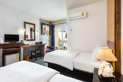 a hotel room with two beds and a desk at PP Insula in Phi Phi Don