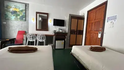 a room with two beds and a table and a kitchen at PP Insula in Phi Phi Don
