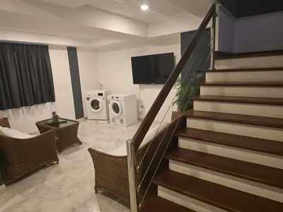 a living room with a staircase with a tv and washing machines at Andaman Seaview house rooftop in Patong Beach