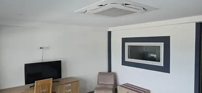 a living room with a flat screen tv and a chair at Andaman Seaview house rooftop in Patong Beach