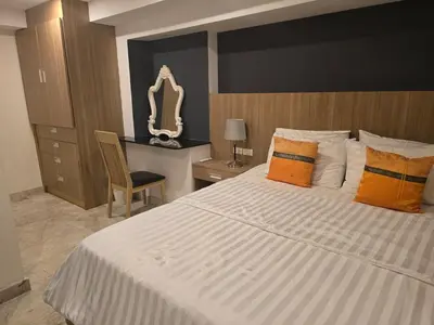 a bedroom with a large white bed with orange pillows at Andaman Seaview house rooftop in Patong Beach