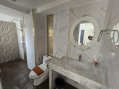 a bathroom with a sink and a toilet and a mirror at Andaman Seaview house rooftop in Patong Beach
