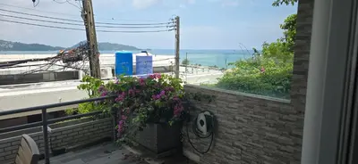 a balcony with flowers and a view of the ocean at Andaman Seaview house rooftop in Patong Beach
