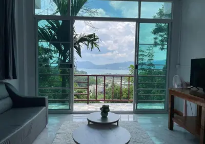 a living room with a large window with a view of the ocean at Amazing Seaview 2-Bedroom House in Patong in Patong Beach