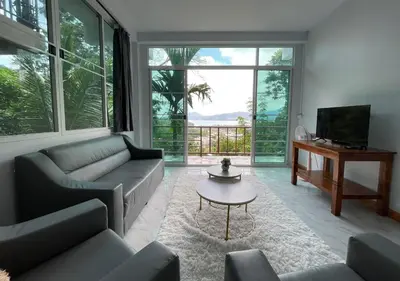 a living room with couches and a table and a tv at Amazing Seaview 2-Bedroom House in Patong in Patong Beach