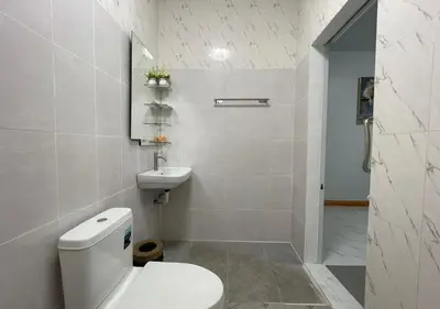 a white bathroom with a toilet and a sink at Amazing Seaview 2-Bedroom House in Patong in Patong Beach