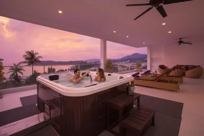 a man and woman in a bathtub in a living room at Oceanview Kata Penthouse - Pasifora in Kata Beach