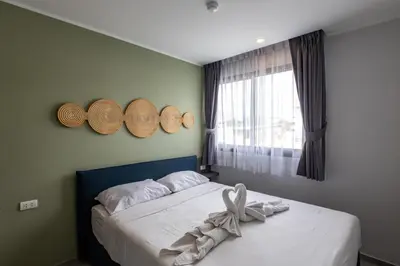 a bedroom with a bed with hats on the wall at Classic Studio Apt T3-329 in Chalong