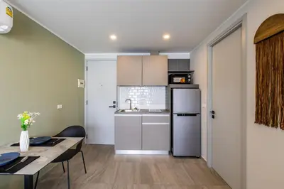 a kitchen and dining room with a table and a refrigerator at Classic Studio Apt T3-329 in Chalong