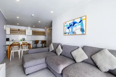 a living room with a couch and a kitchen at Pool View 1 Bed Apt T2-620 in Chalong