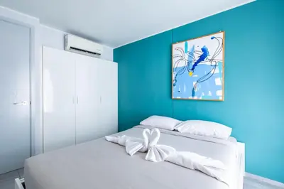 a bedroom with a white bed with a blue wall at Pool View 1 Bed Apt T2-620 in Chalong