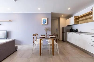 a kitchen and dining room with a table and chairs at Pool View 1 Bed Apt T2-720 in Chalong
