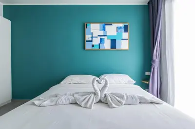 a bed with a bow on it in a blue room at Pool View 1 Bed Apt T2-720 in Chalong