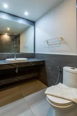 a bathroom with a toilet and a sink and a mirror at Pool View 1 Bed Apt T2-720 in Chalong