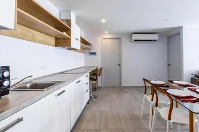 a kitchen with white cabinets and a table with chairs at Pool View 1 Bed Apt T2-720 in Chalong