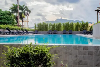a pool at a hotel with chairs and trees at Sleek 2 Bed Apt T2-818 in Chalong